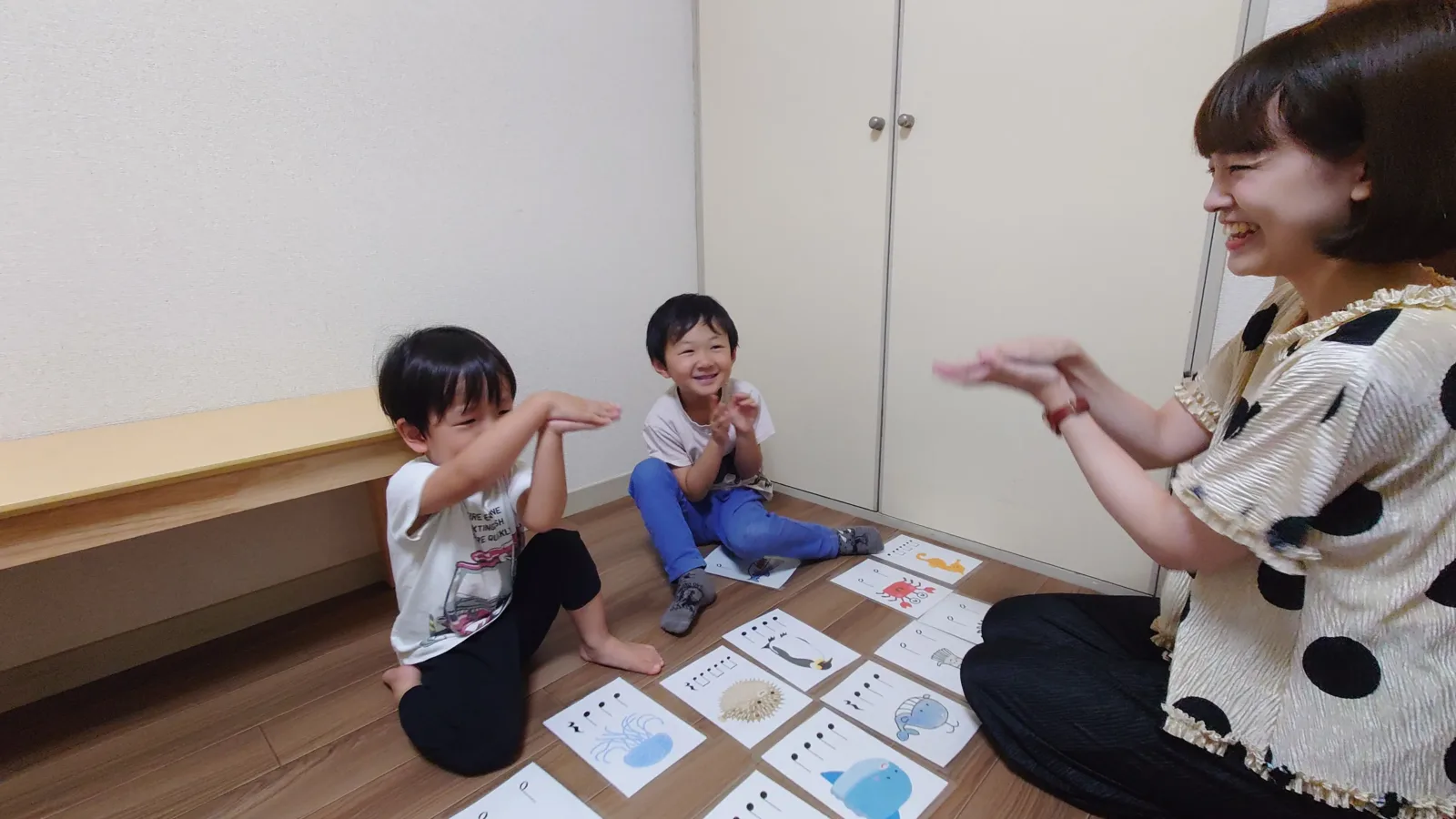 リズムカードを使って先生と手拍子をする子どもたち